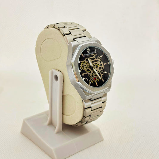 Angled front shot of silver skeleton-style dial watch showcasing sleek case edges and polished finish